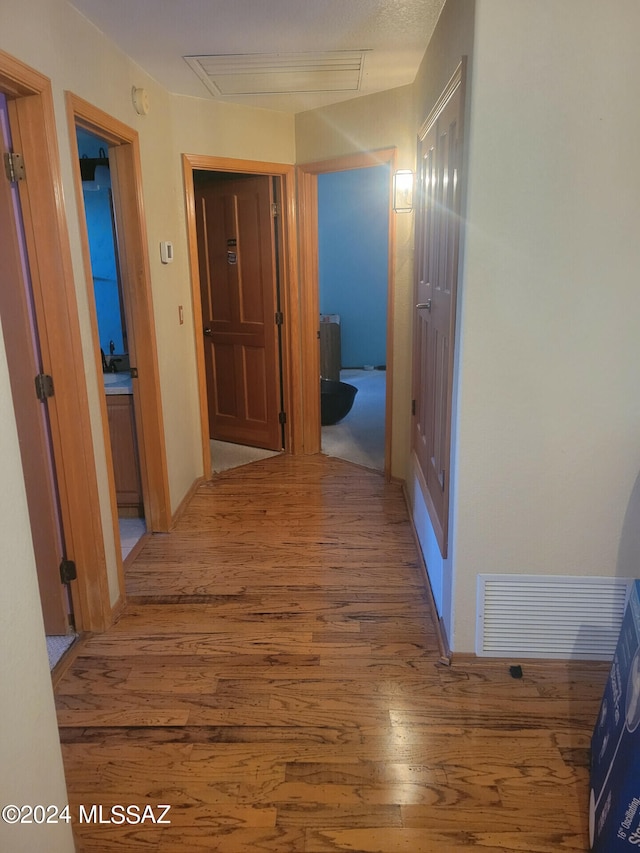 hallway featuring wood finished floors and visible vents