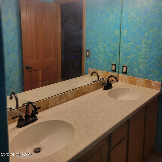 bathroom with wallpapered walls and a sink