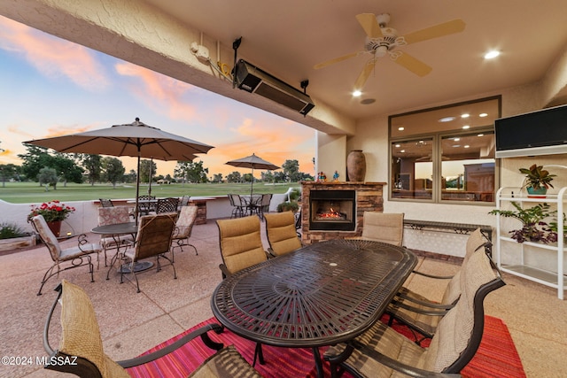 view of patio with ceiling fan and an outdoor stone fireplace