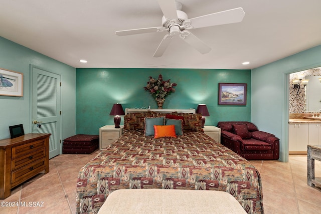 bedroom with a closet, light tile patterned floors, ceiling fan, and ensuite bath