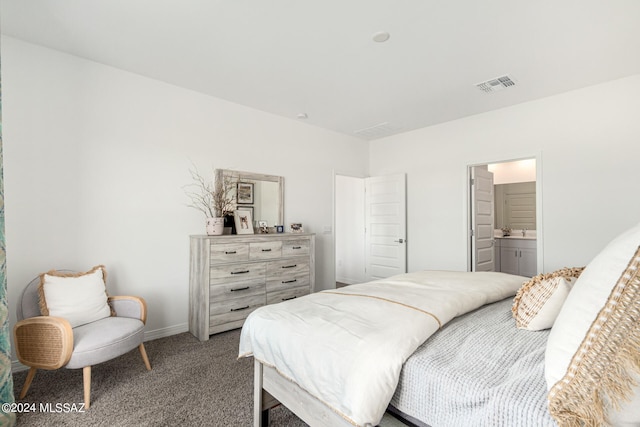 bedroom featuring ensuite bath and carpet floors