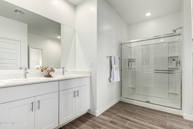 bathroom with walk in shower, wood-type flooring, and vanity