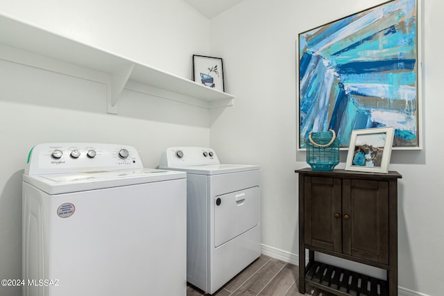 clothes washing area with washing machine and dryer, cabinets, and hardwood / wood-style flooring