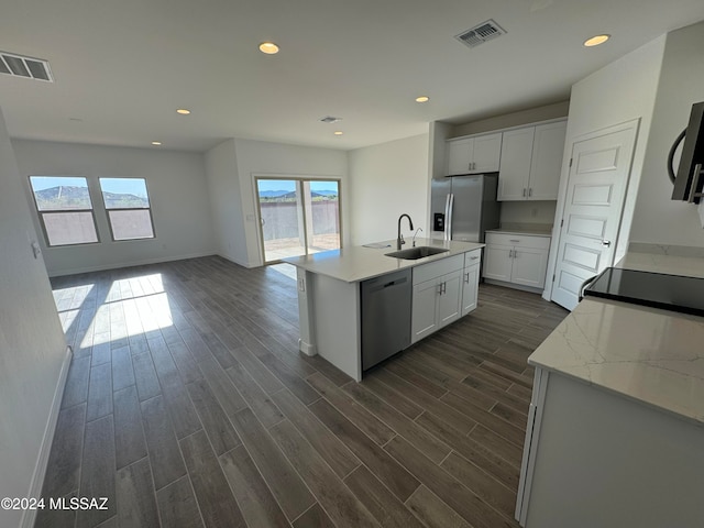 kitchen featuring dark wood-type flooring, an island with sink, appliances with stainless steel finishes, and sink