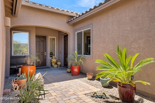 view of exterior entry featuring a patio area