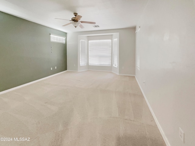 carpeted spare room featuring ceiling fan