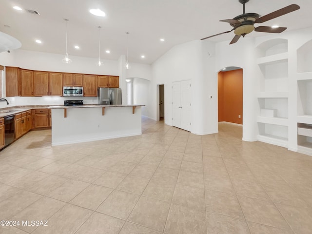 kitchen featuring ceiling fan, stainless steel appliances, a center island, and light tile floors