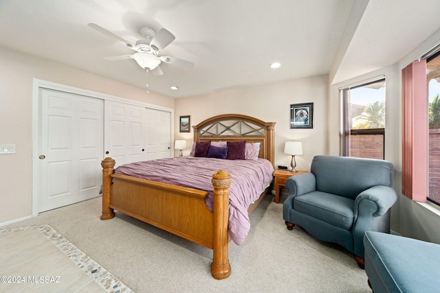 bedroom featuring ceiling fan, light carpet, and a closet