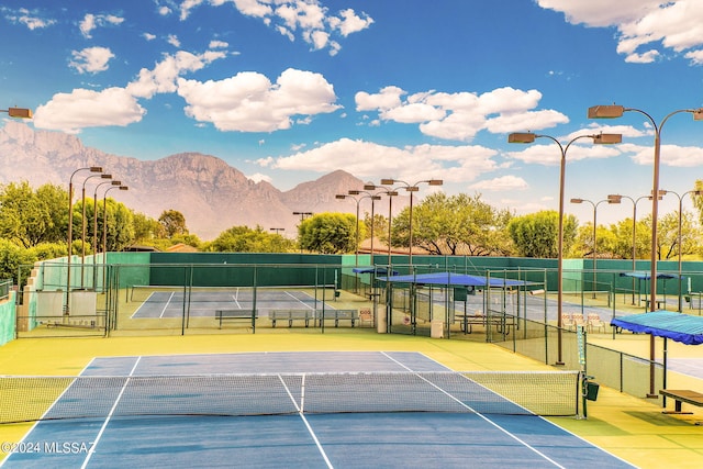 view of sport court featuring a mountain view and basketball hoop