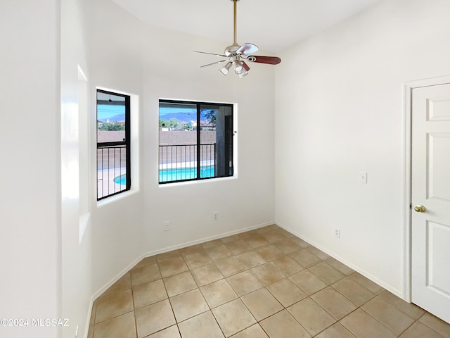 tiled spare room with ceiling fan