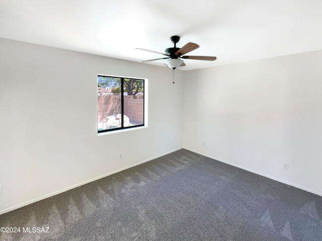 empty room featuring dark colored carpet and ceiling fan