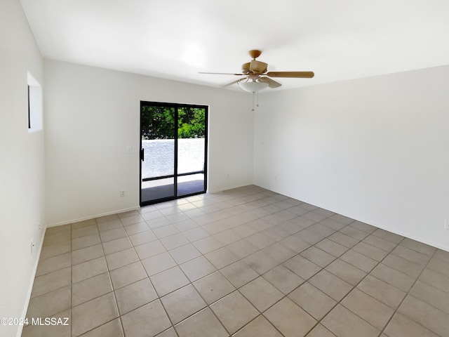 tiled spare room featuring ceiling fan