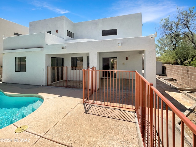 back of house featuring a fenced in pool and a patio area