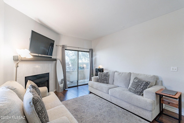 living room with dark wood-type flooring and a fireplace