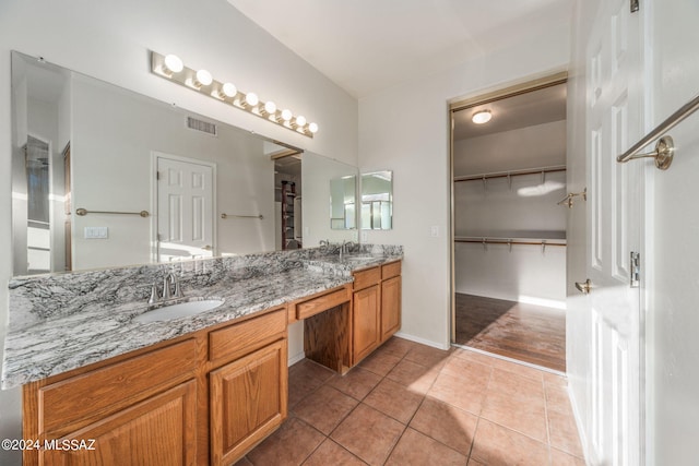 bathroom featuring oversized vanity, dual sinks, and tile flooring