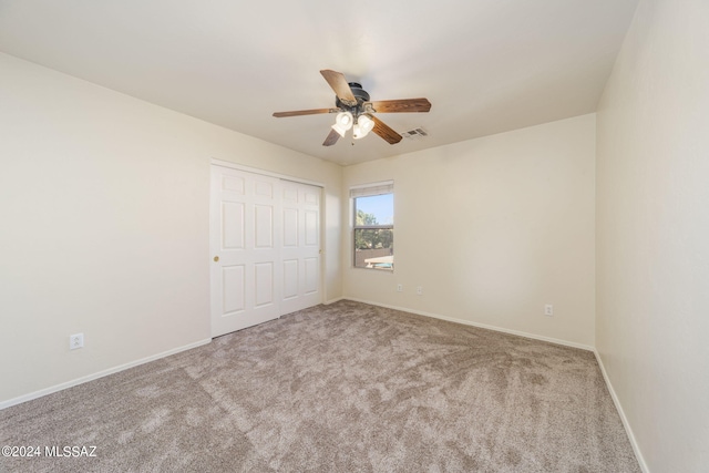 unfurnished bedroom featuring carpet, ceiling fan, and a closet