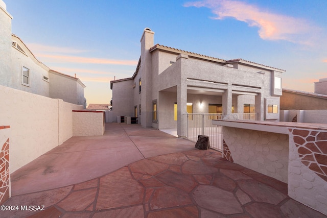 back house at dusk with a patio