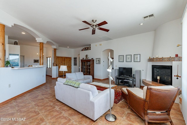 tiled living room featuring ornate columns and ceiling fan