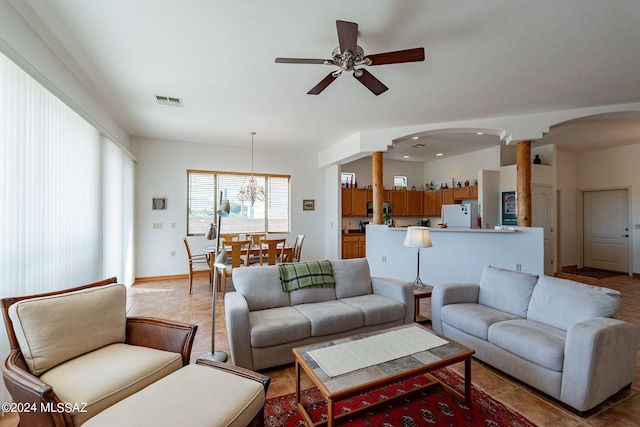 living room with ceiling fan, light tile flooring, and decorative columns