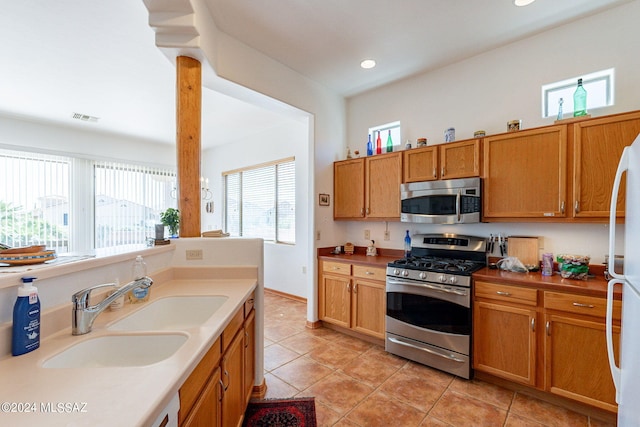 kitchen featuring appliances with stainless steel finishes, sink, and light tile floors