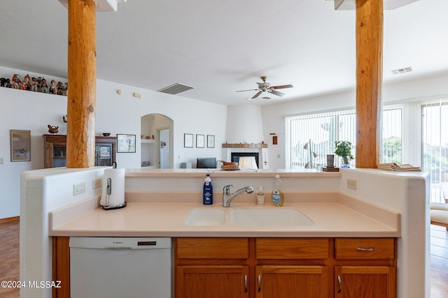 kitchen featuring sink, a fireplace, dishwasher, and ceiling fan