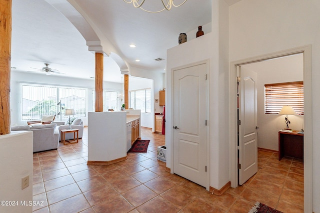 hall featuring ornate columns and light tile floors