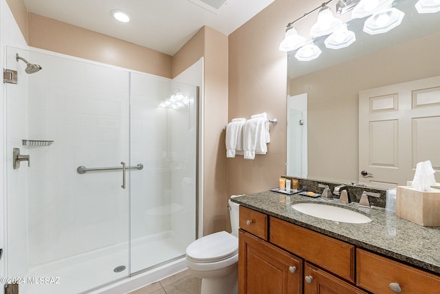 bathroom featuring a shower with shower door, vanity, tile floors, and toilet