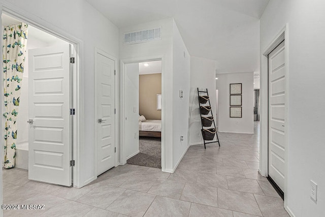 hall featuring light tile flooring