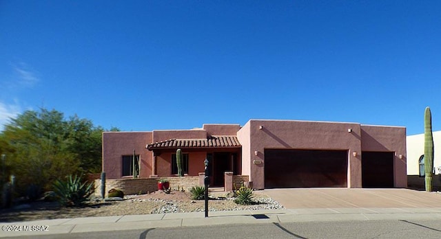 pueblo-style house featuring a garage