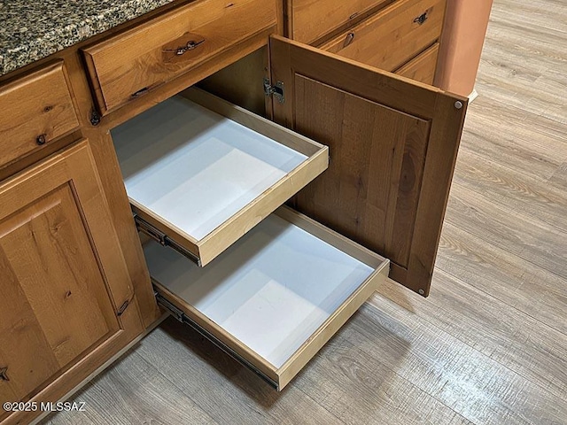 details featuring dark stone countertops and light hardwood / wood-style floors