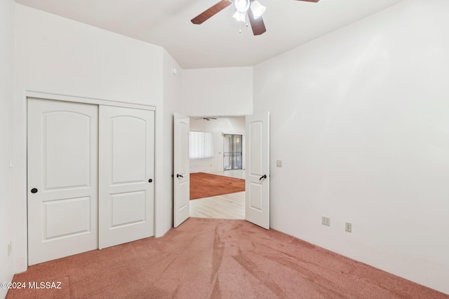 unfurnished bedroom with light carpet, a closet, and ceiling fan