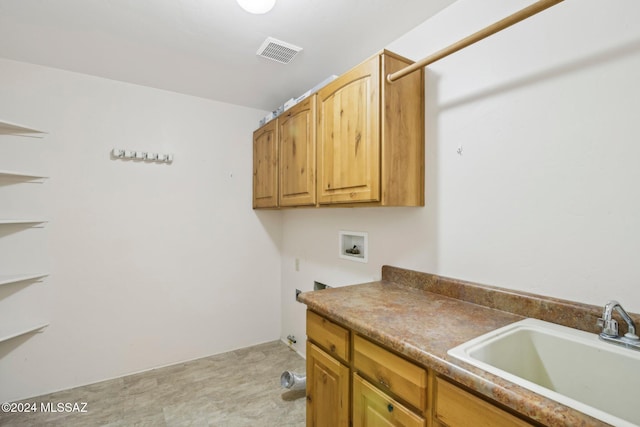 clothes washing area featuring cabinets, washer hookup, and sink