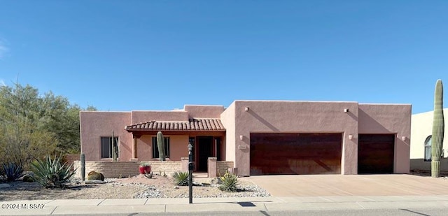 pueblo-style house featuring a garage