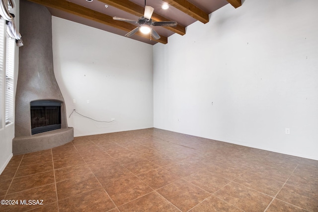 unfurnished living room with tile floors, ceiling fan, lofted ceiling with beams, and a fireplace