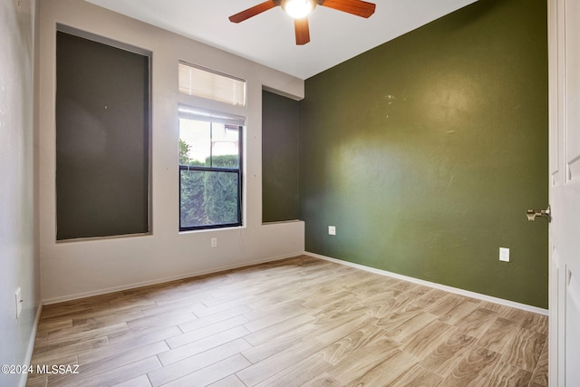 empty room with ceiling fan and light hardwood / wood-style floors