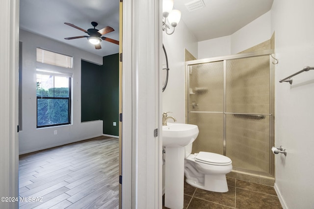 bathroom featuring tile floors, ceiling fan, an enclosed shower, and toilet
