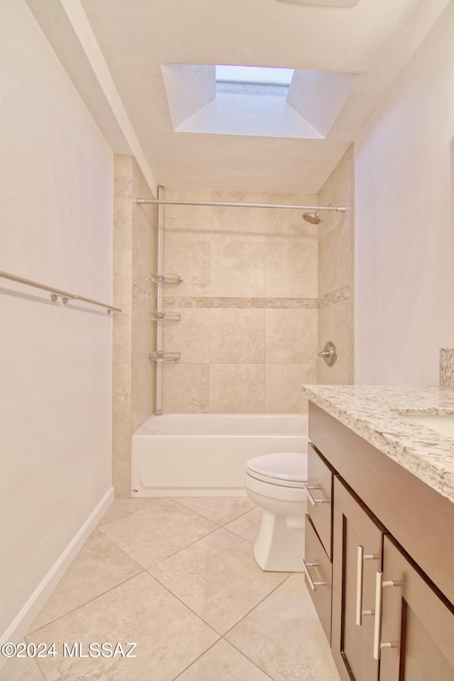 full bathroom featuring vanity, tiled shower / bath, a skylight, tile patterned flooring, and toilet