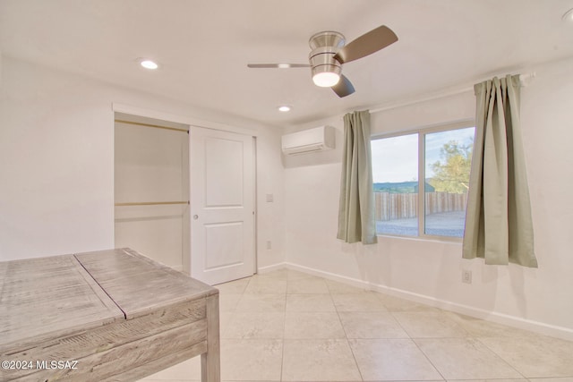 interior space with ceiling fan, an AC wall unit, and light tile patterned floors