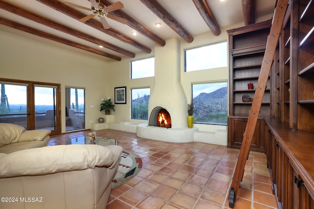 living area featuring light tile patterned floors, a high ceiling, a fireplace, and beam ceiling