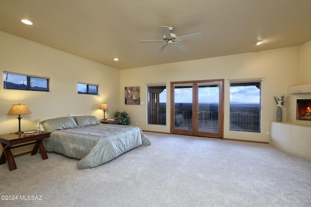 carpeted bedroom featuring a large fireplace and access to exterior