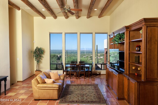 living room featuring light tile patterned flooring, a towering ceiling, a fireplace, beamed ceiling, and a mountain view