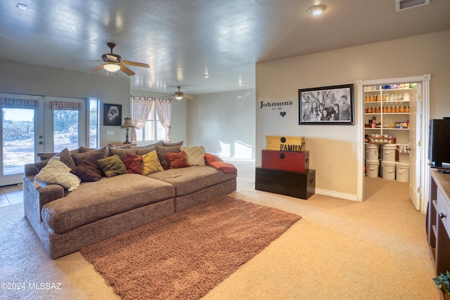 living room featuring light carpet, french doors, and ceiling fan