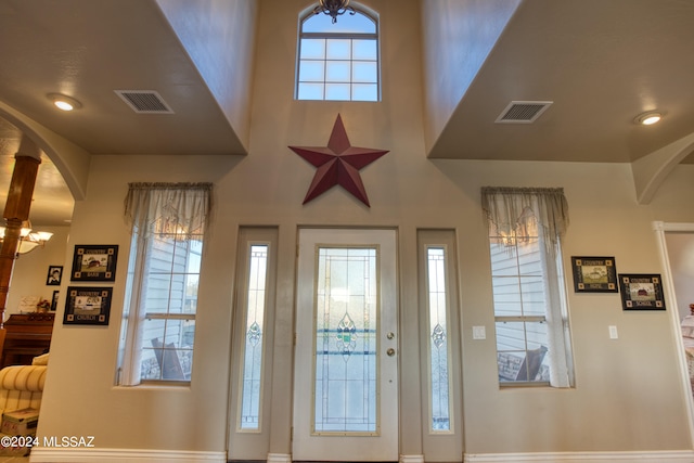 foyer with a wealth of natural light, a chandelier, and a high ceiling