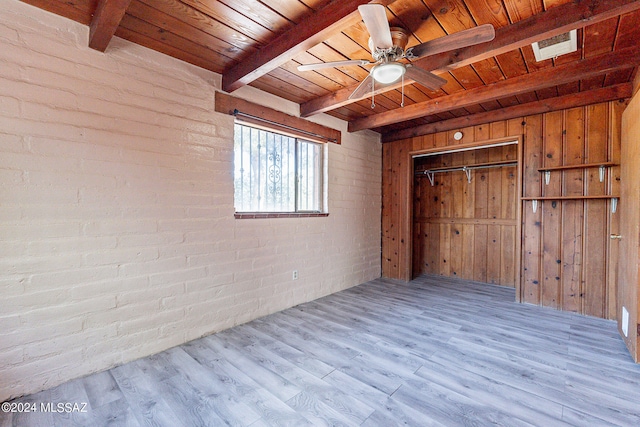 unfurnished bedroom featuring wooden ceiling, brick wall, wood walls, and light hardwood / wood-style flooring