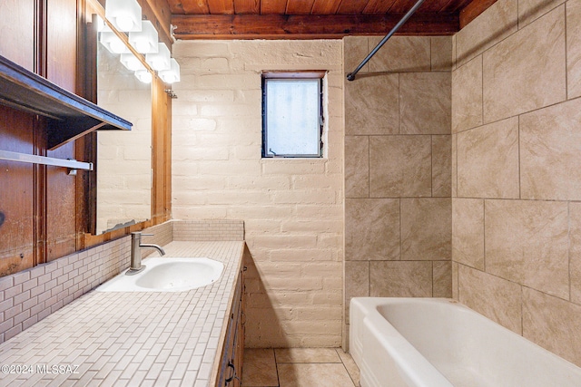 bathroom with brick wall, large vanity, and tiled shower / bath