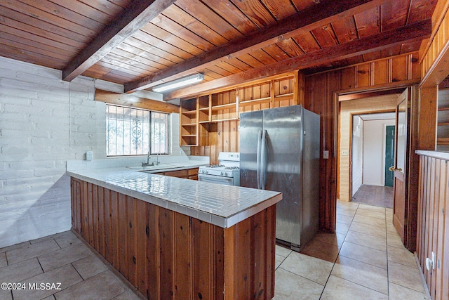 kitchen featuring white gas range oven, wooden ceiling, stainless steel fridge, beamed ceiling, and light tile floors