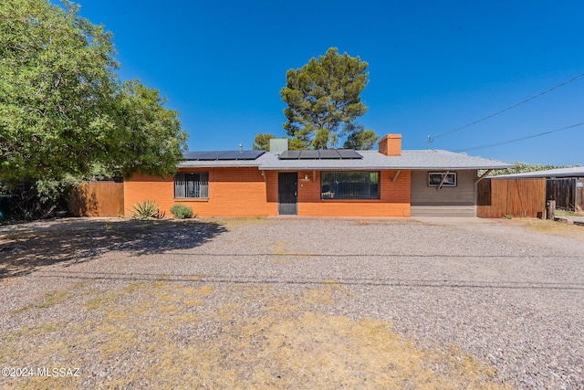 ranch-style home featuring solar panels