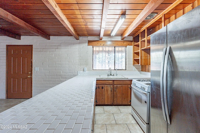 kitchen with stainless steel refrigerator, white range with gas cooktop, beam ceiling, wood ceiling, and sink