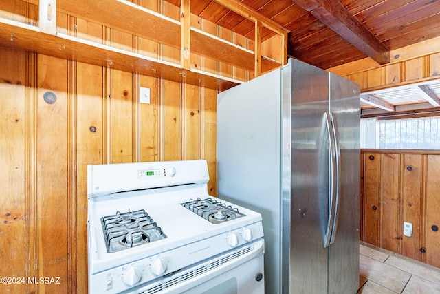 kitchen featuring light tile floors, wooden walls, white gas stove, and wood ceiling