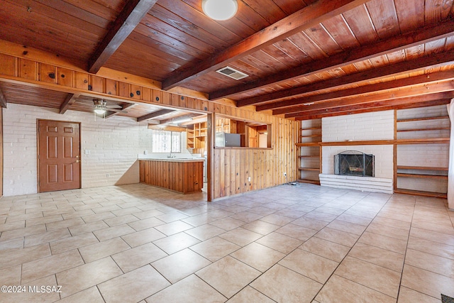 unfurnished living room featuring wood ceiling and brick wall